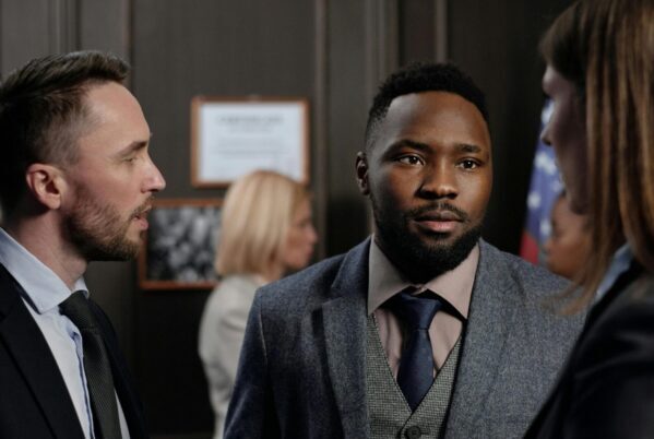 A group of diverse business professionals engaged in a focused discussion indoors.