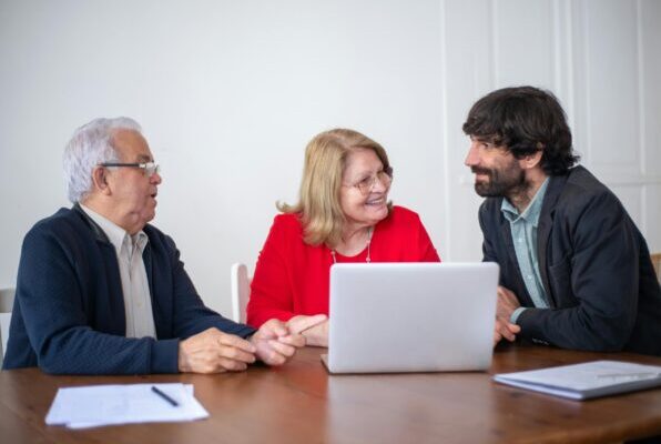 Elderly couple having a consultation with a professional advisor in a bright indoor setting.